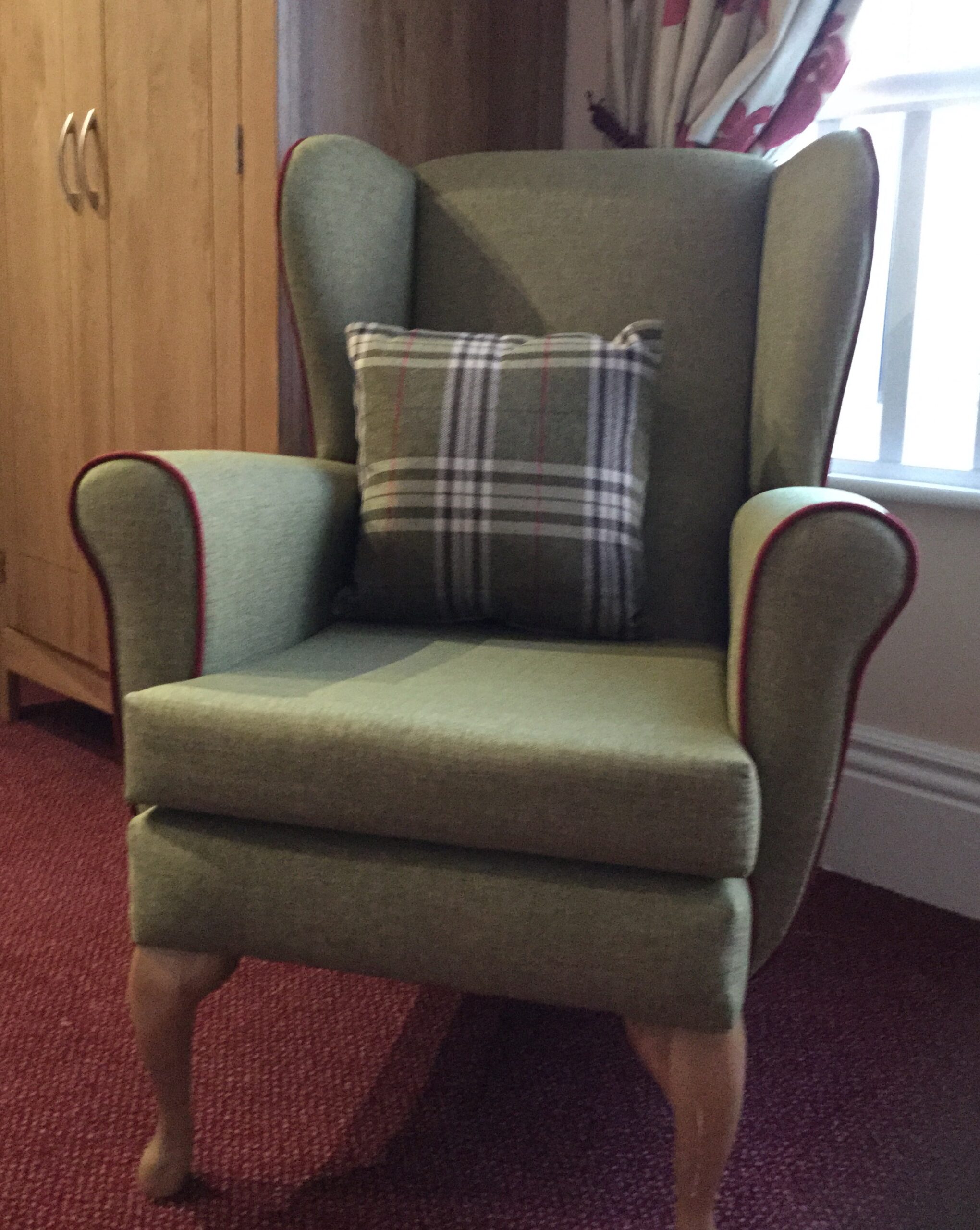 Wing chair with contrast piping on arms