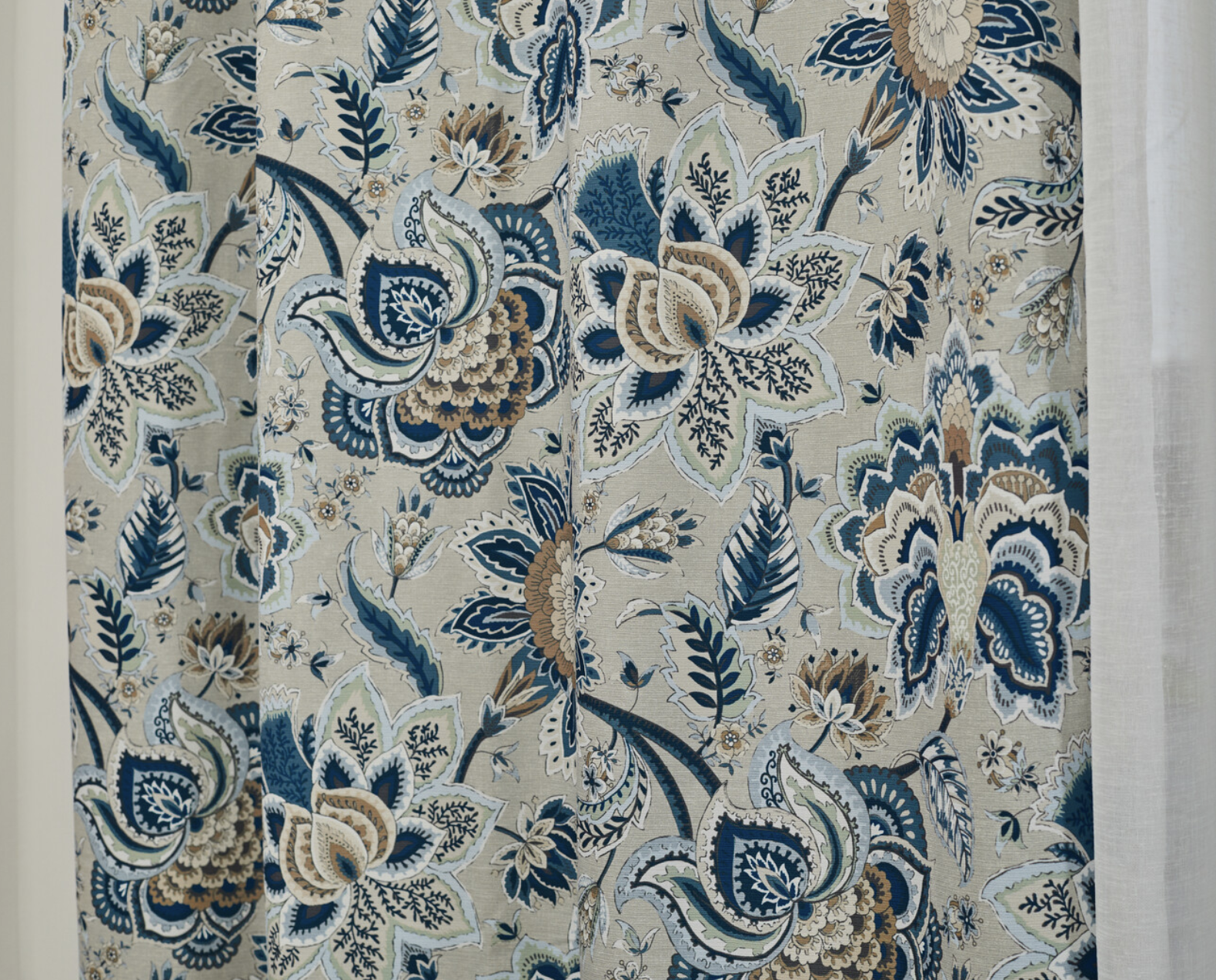 A pair of floral curtains. blue design on a cream background
