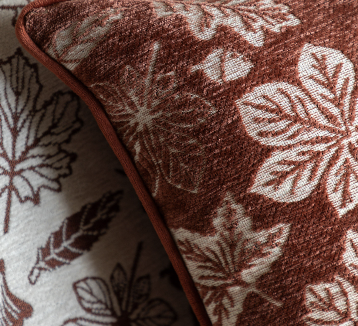 Rust coloured chenille cushion on a sofa