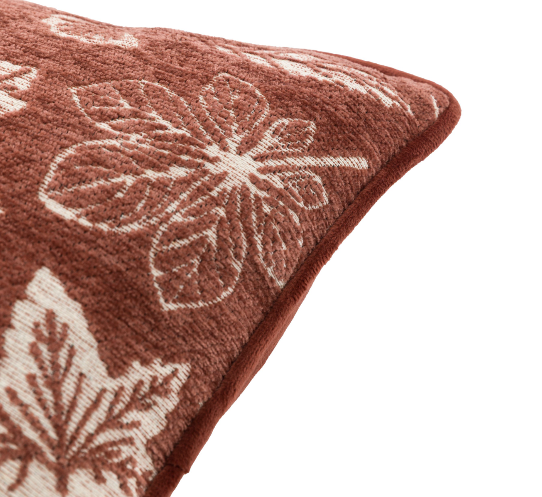 Piping detail of a chenille coloured cushion with leaf design.